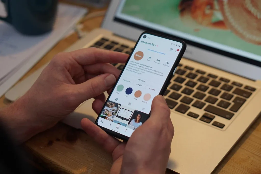 Hands holding a smartphone displaying an Instagram profile
